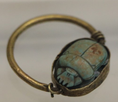 An Egyptian scarab ring featuring a vibrant turquoise stone, symbolising protection and transformation in ancient culture.