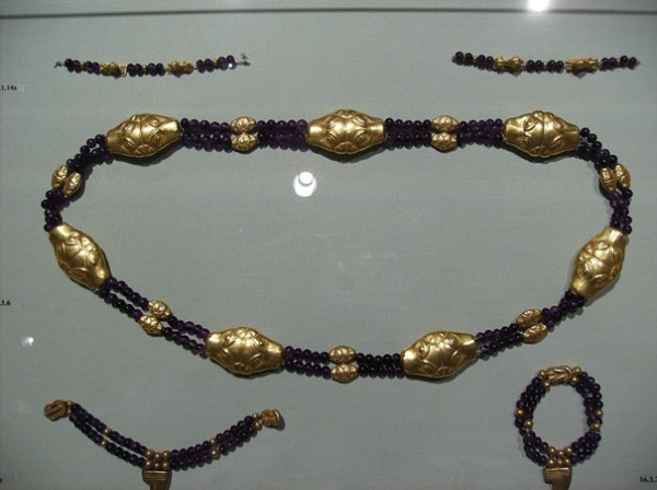 A gold and black beaded anklet, elegantly designed