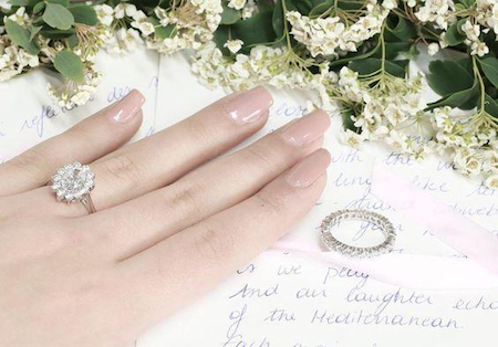 woman’s hand decorated with a floral wavy engagement ring, perfectly suited for summer engagement