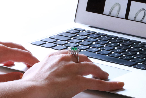 Individual engaged in online ring shopping on a laptop, highlighting a selection of beautiful rings