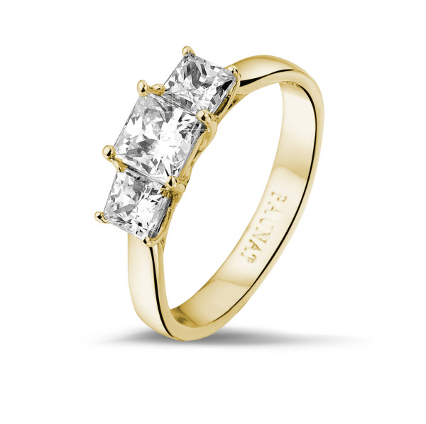 elegant yellow gold engagement ring with three princess cut diamonds.