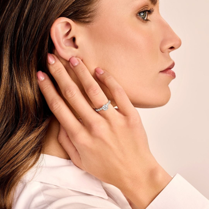 confident women showing off her perfect engagement ring in solitaire setting surrounded by smaller diamonds