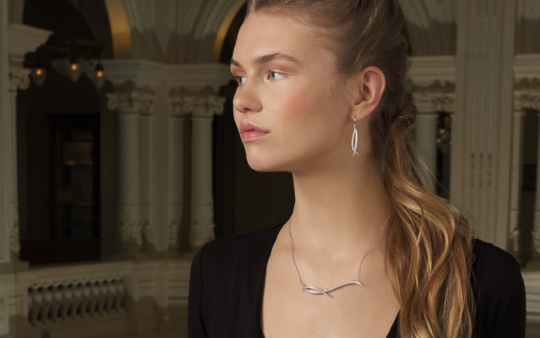 woman in black little dress wearing elegant, abstract shaped diamond earrings from the nathu collection