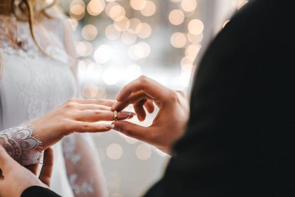 BAUNAT - modern bir düğün töreni sırasında gelinin yüzük parmağına yüzük takan bir damat