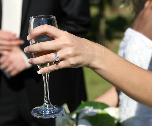 Bruid houdt een glas wijn vast dat ze koos tijdens de huwelijksplanning – BAUNAT